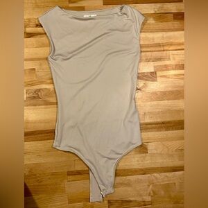 Cream bodysuit with a slight scoop neck and short sleeves